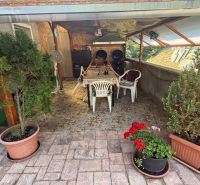 Die Terrasse eines Einfamilienhauses in Zvolen mit Holzdekor, einem Tisch und Pflanzen in Töpfen.