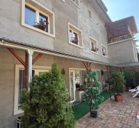 Ein Einfamilienhaus in Zvolen mit grünen Pflanzen auf der Terrasse und Fenstern mit Blumen.