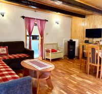 Wohnzimmer mit Kamin, Fernseher und Holzboden in einem Einfamilienhaus.