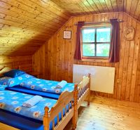 Innenraum aus Holz mit Holzboden und zwei Betten in einem Einfamilienhaus.