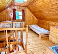 Das Dachgeschoss eines Einfamilienhauses mit Holzverkleidung und einem Boden in Holzoptik.