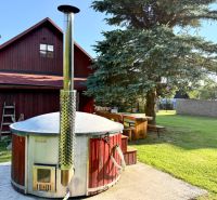 Ein Einfamilienhaus in der Jána Švermu Straße in Šumiac mit einem Whirlpool und einem Holztisch im Garten.