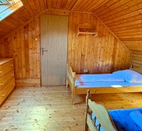 Ein Dachzimmer in einem Einfamilienhaus mit Holzelementen und einfacher Einrichtung.
