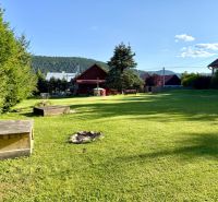 Garten bei einem Einfamilienhaus in der Straße Jána Švermu in Šumiac mit Rasen und Feuerstelle.
