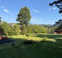 Einfamilienhaus in Šumiac in der Straße Jána Švermu, Rasenfläche mit Spielplatz umgeben von Natur.