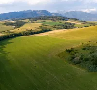Blick auf die weitläufigen Felder in Liptovský Trnovec mit Bergen. Ungewöhnliche Immobilien.