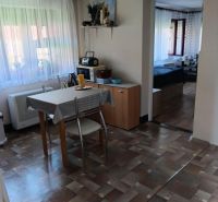 Esszimmer mit verglasten Fenstern, Tisch, Stühlen und Boden mit Holzdekor.