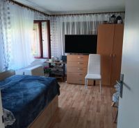 Zimmer mit Fernseher, Bett und Holzboden, Grundstücke - Wohnen.
