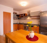 Küche in einer 4-Zimmer-Wohnung mit Holzdekor und gelbem Blumenzubehör.