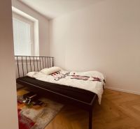 Schlafzimmer mit einem Eisenbett und einem Boden mit Holzdekor in einer 4-Zimmer-Wohnung.