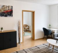 Wohnzimmer in einer 2-Zimmer-Wohnung mit Holzboden und einem Bild von Paris.