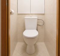 Badezimmer in einer 2-Zimmer-Wohnung mit beigen Fliesen und Toilette.