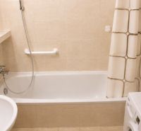 Badezimmer in einer 2-Zimmer-Wohnung mit Badewanne, Dusche und Waschmaschine.