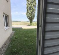 Blick aus dem Fenster auf den Rasen und den Baum bei einer Einzimmerwohnung in Zlaté Moravce.