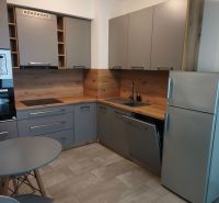 Stilvolle moderne Küche mit Holzboden in einer Einzimmerwohnung.
