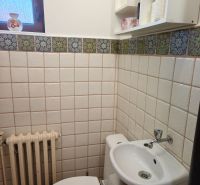Badezimmer in einem Einfamilienhaus mit Toilette, Waschbecken und Fenster, gefliest.