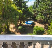 Blick aus dem Einfamilienhaus in Mankovce auf den grünen Garten mit Pool.