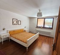 Schlafzimmer mit Bett und Holzboden in einem Einfamilienhaus.