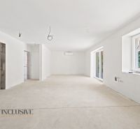 Geräumiges Interieur eines Einfamilienhauses mit weißen Wänden und großen Fenstern.