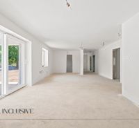 Ein luftiges Interieur mit weißen Wänden und großen Fenstern in einem Einfamilienhaus.