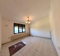 Wohnzimmer in einem Einfamilienhaus mit Fliesen und Fenstern.