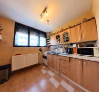 Küche mit braunen Schränken und einem geräumigen Fenster in einem Einfamilienhaus.