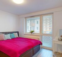 Schlafzimmer mit großem Bett, Nachttisch und Frisiertisch mit Spiegel in einer 3-Zimmer-Wohnung.
