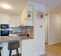 Küche mit Bartresen und Holzboden in einer 3-Zimmer-Wohnung.