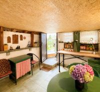 Das Innere der Hütte mit rustikalen Möbeln, Regalen und einer Vase mit Blumen.
