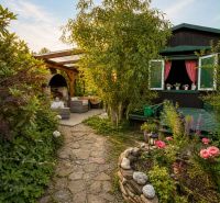 Der Garten bei der Hütte in Žilina mit steinernen Wegen und einem Blumenbeet.