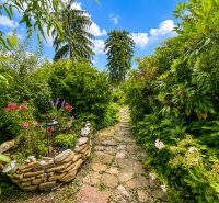 Ein Garten bei der Hütte in Žilina mit einem Steinweg und einem Blumenbeet.