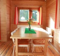 Holzverkleidung, Tisch mit Blumen, Boden mit Holzdekor und bunte Vorhänge, Hütte.