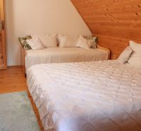 Ein Schlafzimmer in einer Hütte mit zwei Betten, einem Dachboden und einem Boden mit Holzdekor.