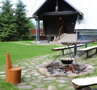 Blockhütte in Tále in Brezno mit Feuerstelle und Holzbänken im Rahmen von Hotels und Pensionen.