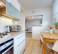 Küche in einer 3-Zimmer-Wohnung mit Holzboden und Esstisch.