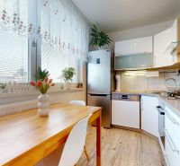 Küche in einer 3-Zimmer-Wohnung mit Holzboden, hellem Interieur voller Pflanzen.