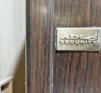 Detail der Sicherheitstür ADLO in einer 3-Zimmer-Wohnung, Boden mit Holzdekor.
