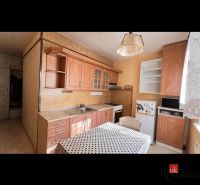 Küche mit Holzelementen, Schränken und Esstisch in einer 2-Zimmer-Wohnung.