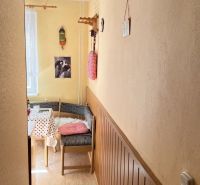 Gemütliche Ecke in einer 2-Zimmer-Wohnung mit Holzboden und bunten Dekorationen.