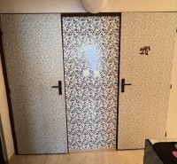 Tapezierte Türen im Inneren einer 2-Zimmer-Wohnung mit Holzboden.
