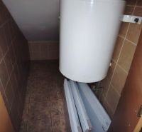 Technikraum im Badezimmer mit Boiler und Heizkörpern auf einem Boden mit Fliesendekor.