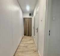 Ein Flur mit weißen Wänden und einem Boden in Holzoptik in einer 3-Zimmer-Wohnung.
