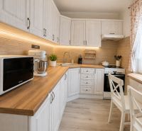 Küche in einer 3-Zimmer-Wohnung mit Holzboden und weißen Möbeln.