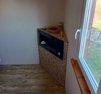 Innenraum mit Wandkamin, dekorativer Verkleidung und Boden mit Holzdekor.