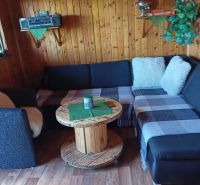 Holzinterieur mit Sofa, Spulentisch und Boden mit Holzdekor.