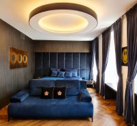 Luxuriöses Zimmer mit blauen Möbeln, Holzboden und großem Fenster.