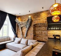 Design-Innenraum einer 2-Zimmer-Wohnung mit Ziegelwand und bequemer Couch.