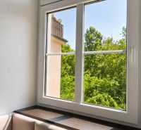 Helles Zimmer mit bequemen Sitzgelegenheiten und großem Fenster, 2-Zimmer-Wohnung.