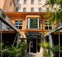 Ein Restaurant am Hviezdoslav-Platz in Bratislava - Altstadt, umgeben von Grün und Palmen.