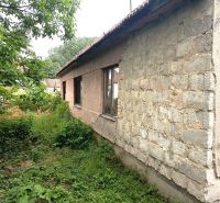 Ein älteres Familienhaus in Nové Zámky mit einem ungepflegten Garten und einer Holzdachkonstruktion.